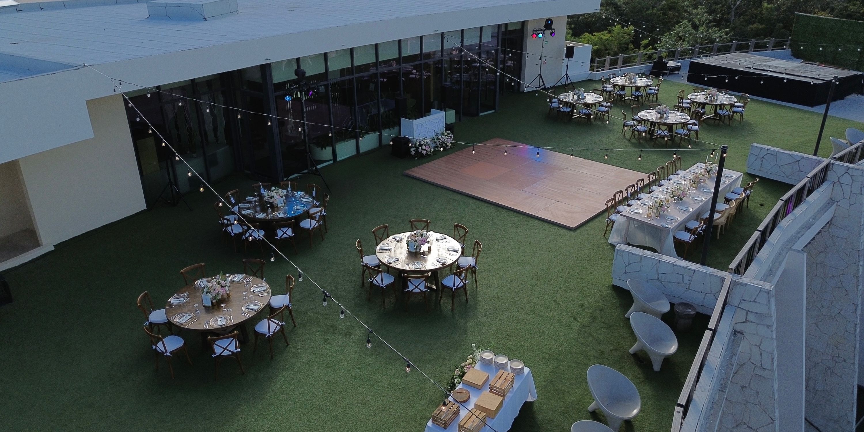 Destination wedding setup at Secrets Tulum with tables encircling a central lawn dance floor.