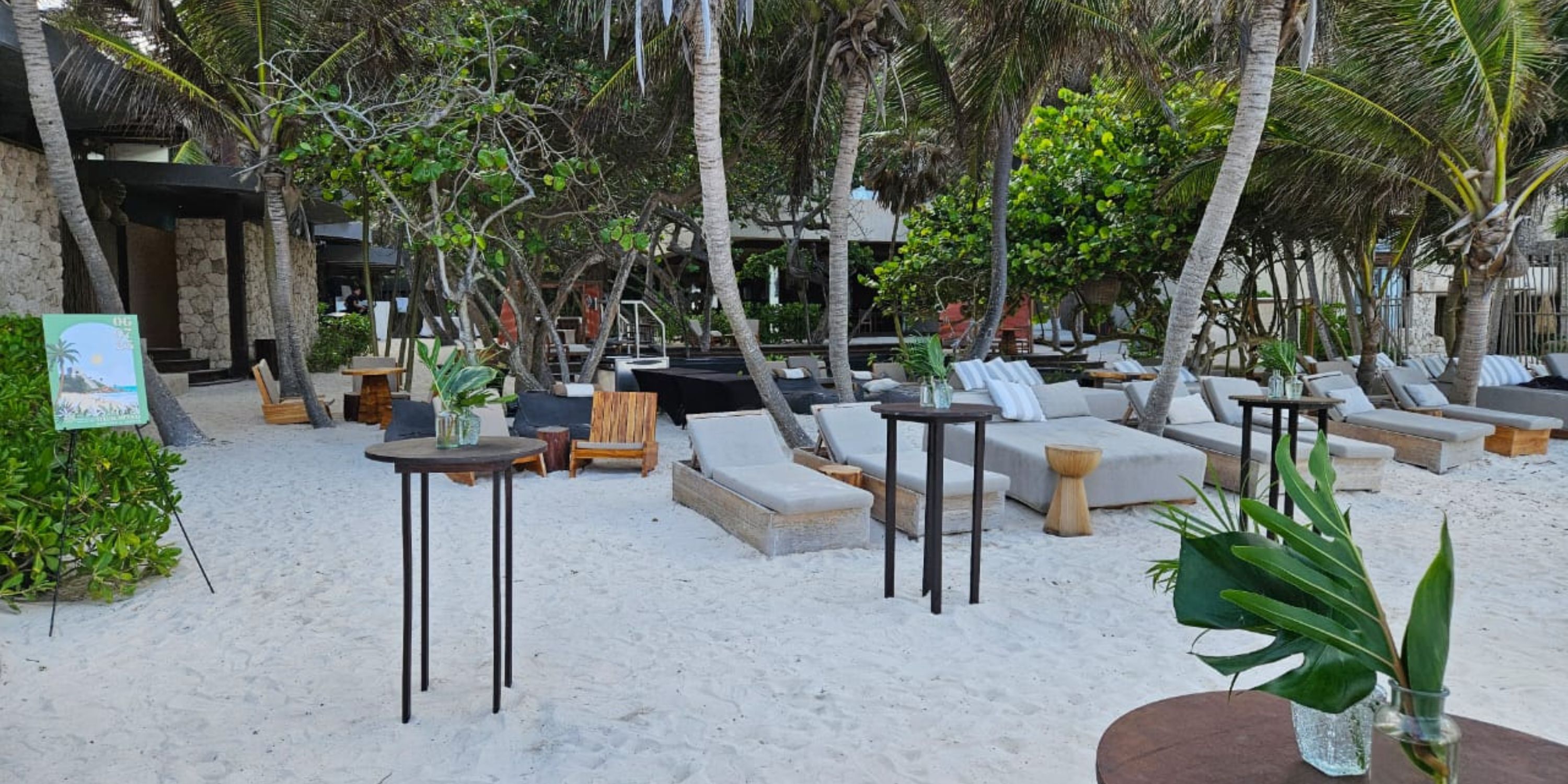 Secrets Tulum offers a beach lounge with sofas and palm trees, perfect for a dreamy destination wedding.