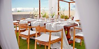 Secrets Tulum: Outdoor wedding table setup with wooden chairs, white linens, and potted plants.
