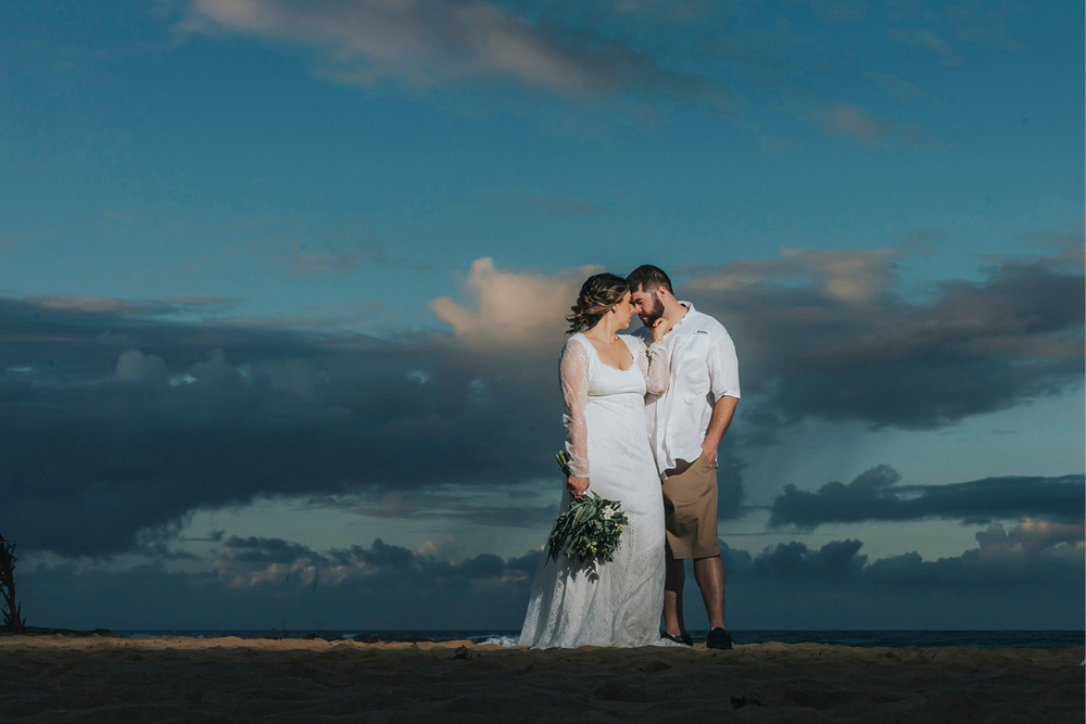 Couple kissing on the beach after their How To Afford A Destination Wedding for $15,000 or Less 