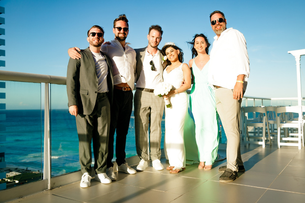 Group posing for a picture with the ocean in the distance