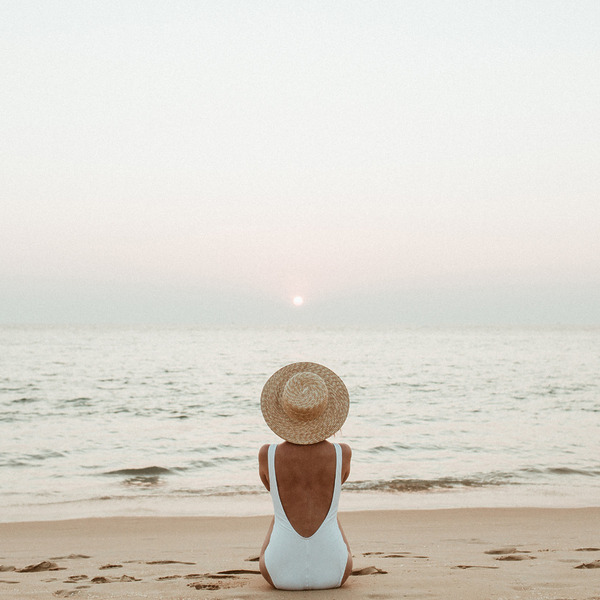 Woman sitting on the beach during destination travel