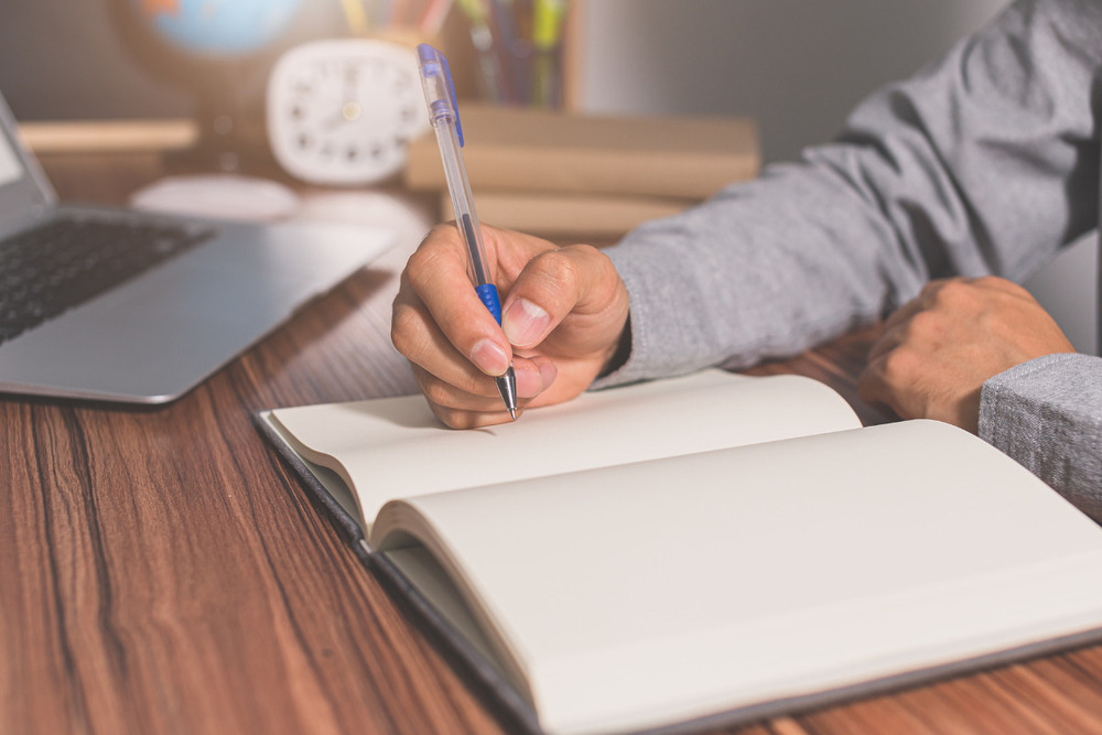 man writing in memory book