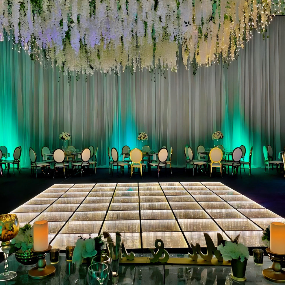 A destination wedding reception with green and white flowers hanging from the ceiling.