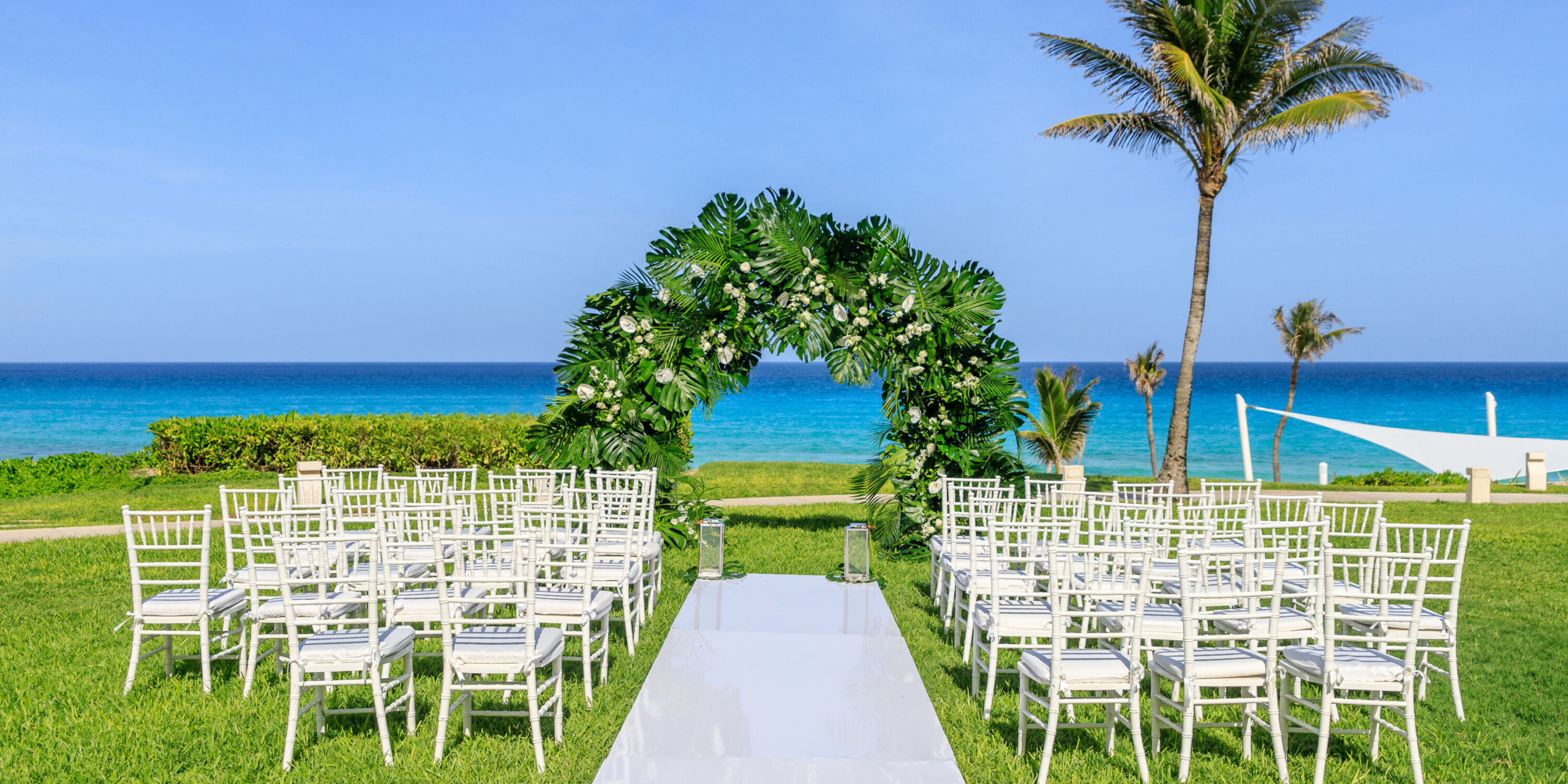 A destination wedding ceremony set up in front of the ocean.