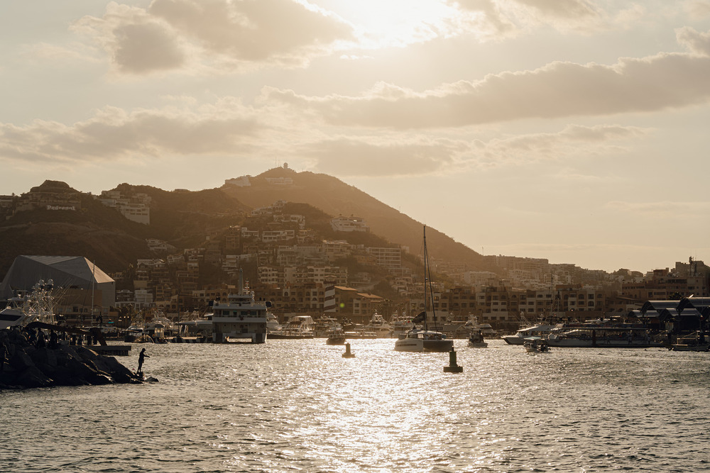 Boats docked in a harbor at sunset create a peaceful setting, perfect for a wedding or destination wedding unity ceremony.