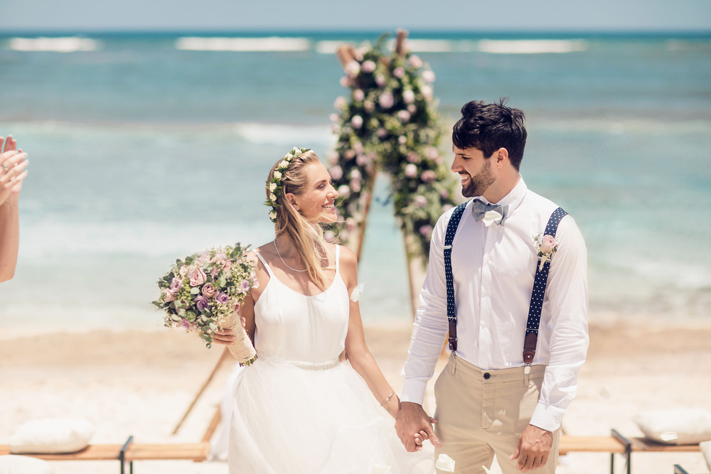 A man and woman holding hands and smiling at each other during their destination wedding at one of the most beautiful wedding locations.