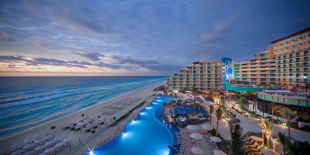 Resort with a pool and lounge chairs—ideal for unforgettable destination weddings at sunset by the beach.