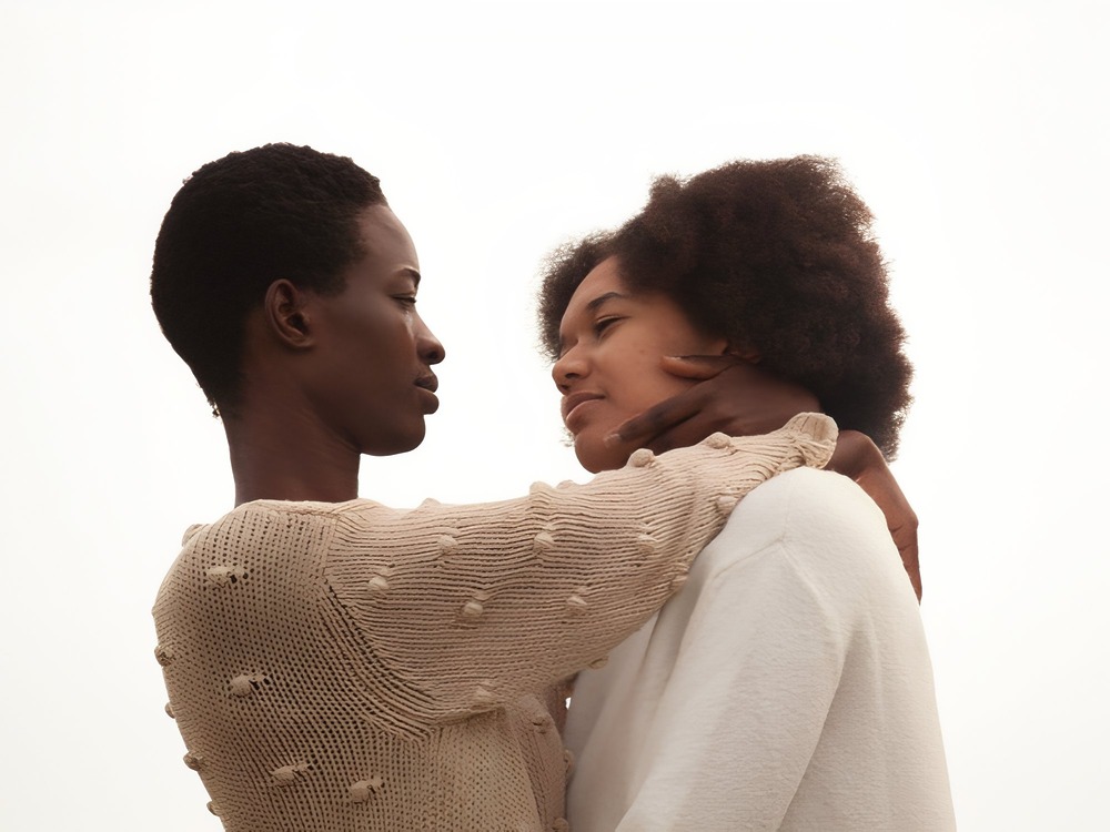Two people stand close together, sharing a loving gaze at their intimate LGBTQ+ destination wedding.
