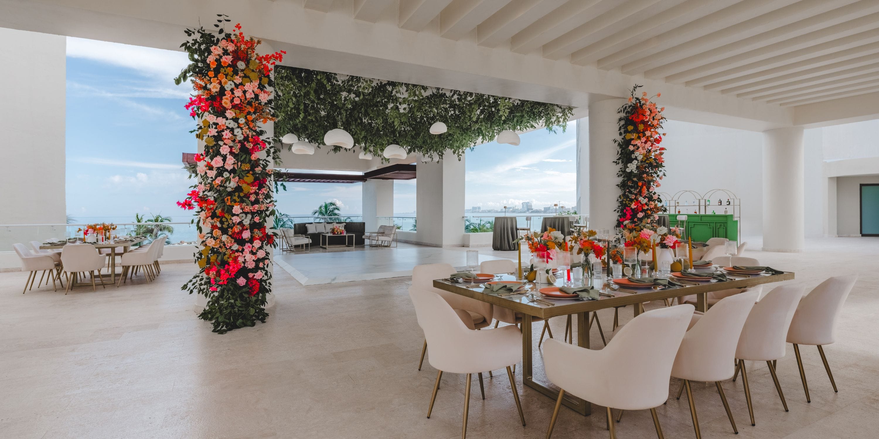 Chic open-air destination wedding space for older couples, with floral columns and lounge area.