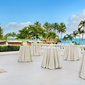 A table set up on a patio overlooking the ocean.