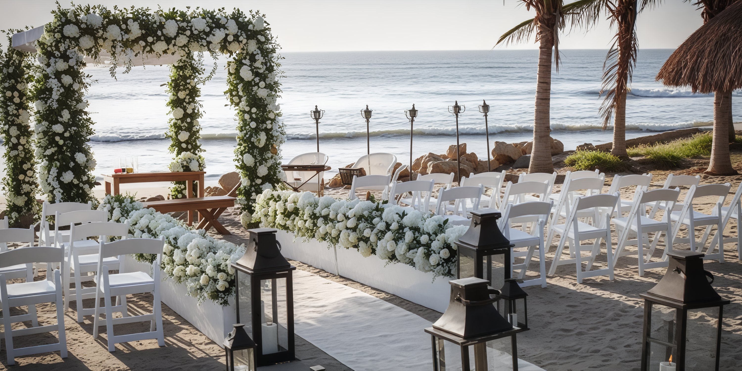 Seaside destination wedding arrangement featuring a floral arch, elegant white chairs, and decorative lanterns.