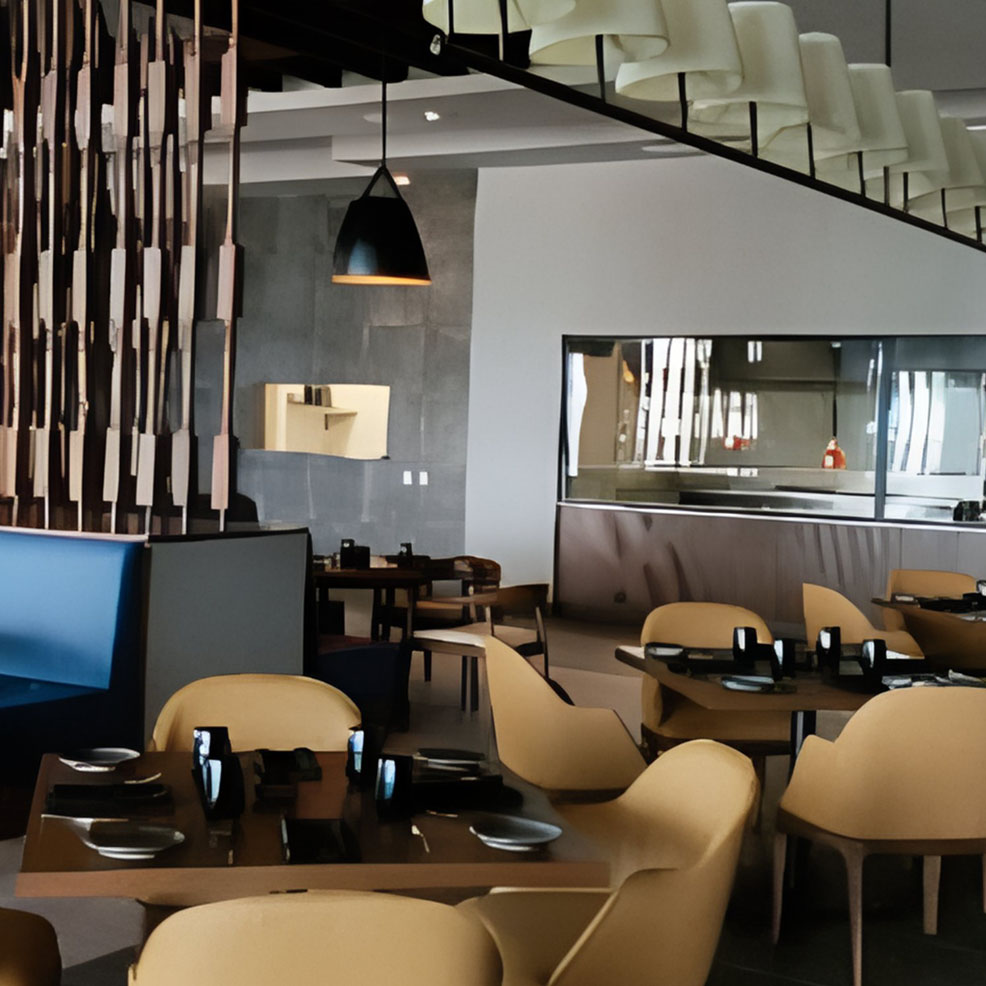 The interior of a restaurant with yellow chairs and tables.