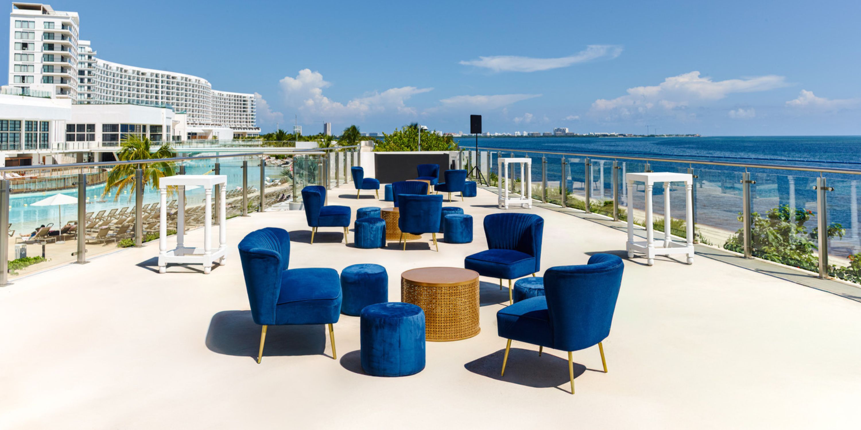Rooftop terrace at AVA Resort Cancun set for a destination wedding, blue velvet chairs, ocean views.