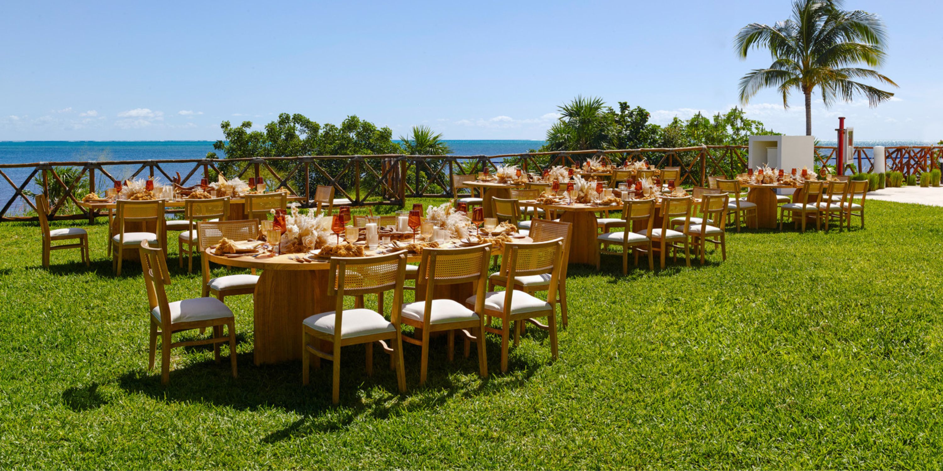 Outdoor dining at AVA Resort Cancun, perfect for a destination wedding, with tables by water and palms.