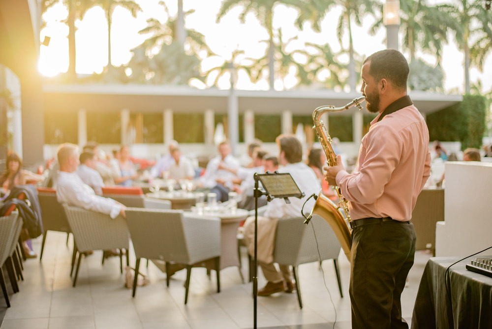 As the sun sets, a man serenades guests with his saxophone at a destination wedding in Costa Rica.