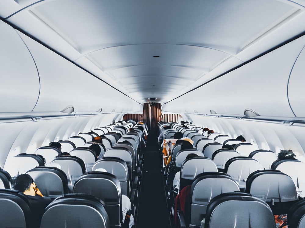 Here’s a rewrite that incorporates your requested terms: The interior of a commercial airplane—perfect for sharing destination wedding tips on how to pack and transport wedding dresses and suits.