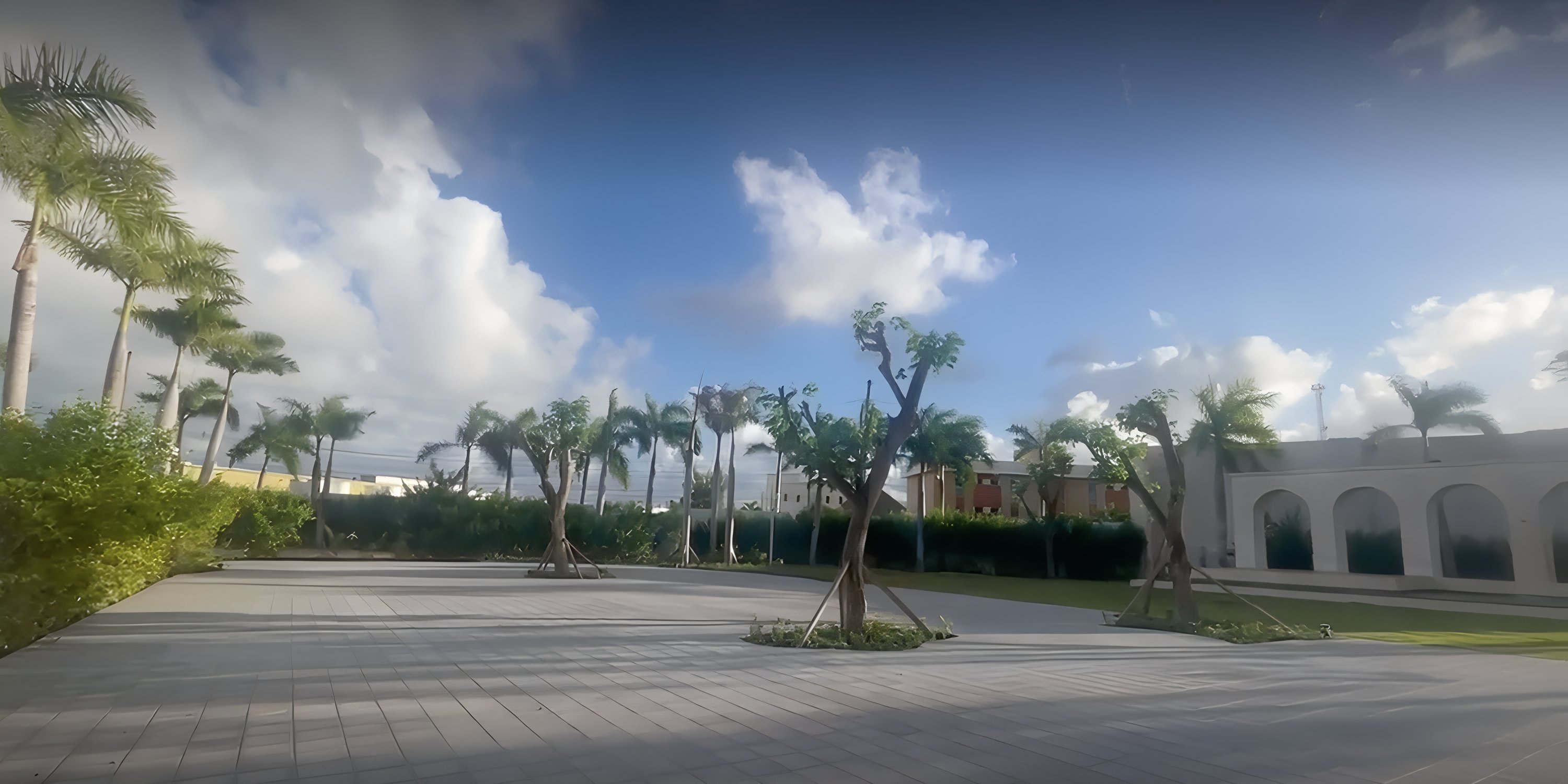 Open courtyard at Secrets Tides, perfect for a destination wedding, with palm trees and a cloudy sky.