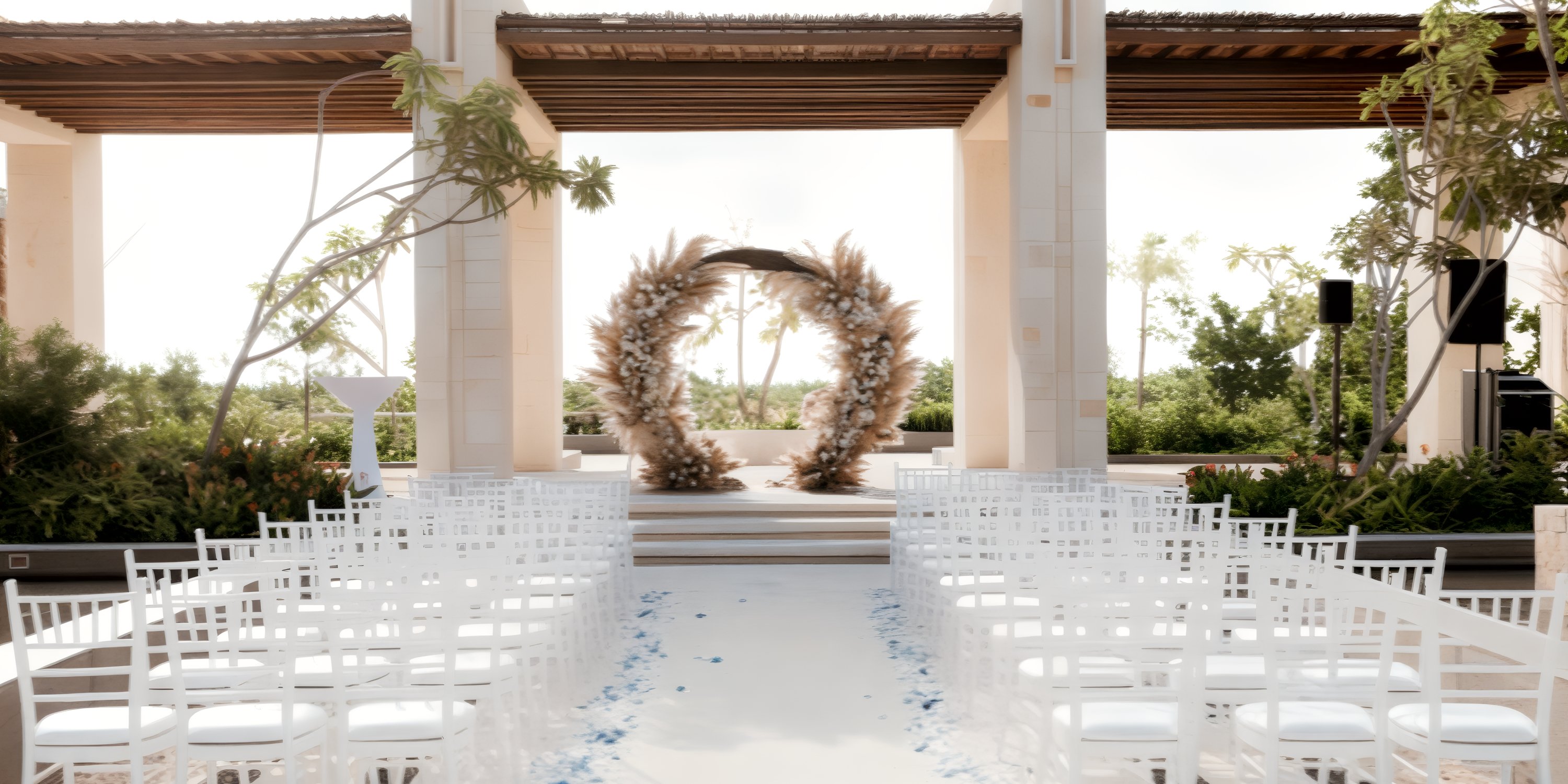 Destination wedding at Secrets Playa Blanca: white chairs, floral arch, and lush greenery outdoors.