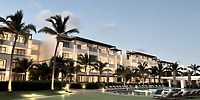 Secrets Tides resort at dusk, perfect for a destination wedding with balconies, palm trees, and pool area.