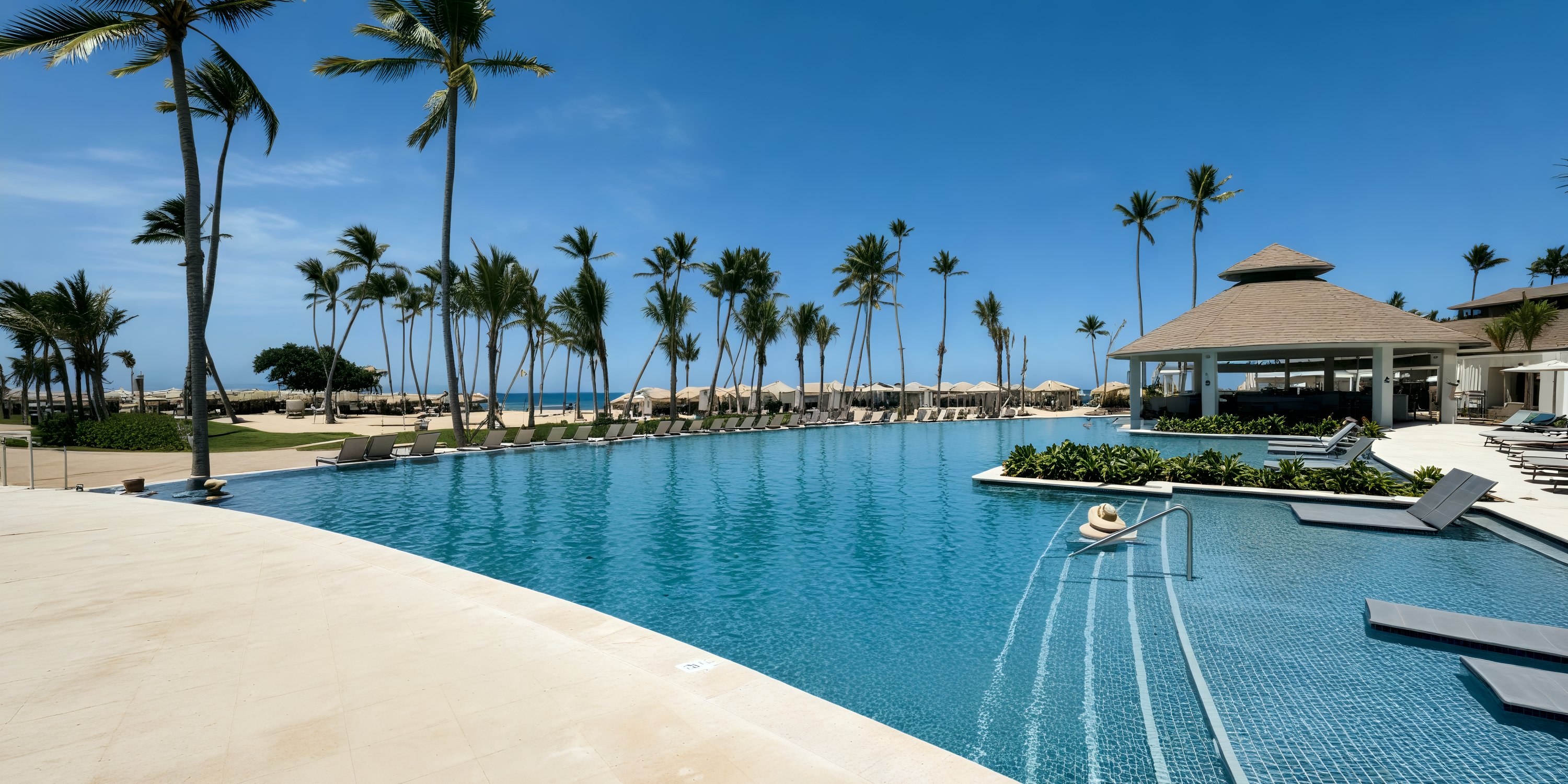 Secrets Tides offers a stunning destination wedding backdrop with a large pool, lounge chairs, and palms.
