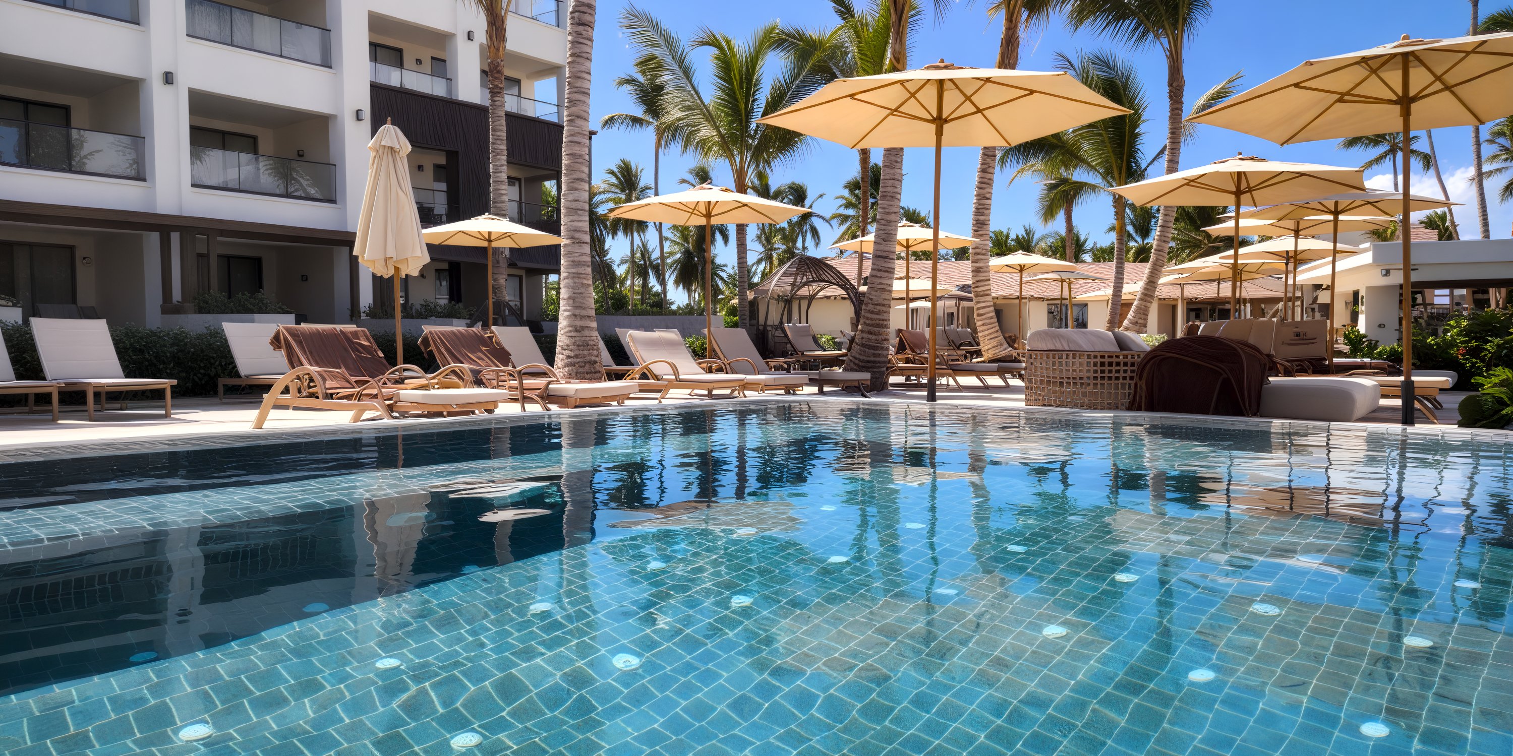 Poolside view with lounge chairs and umbrellas at Secrets Tides, perfect for a sunny destination wedding.