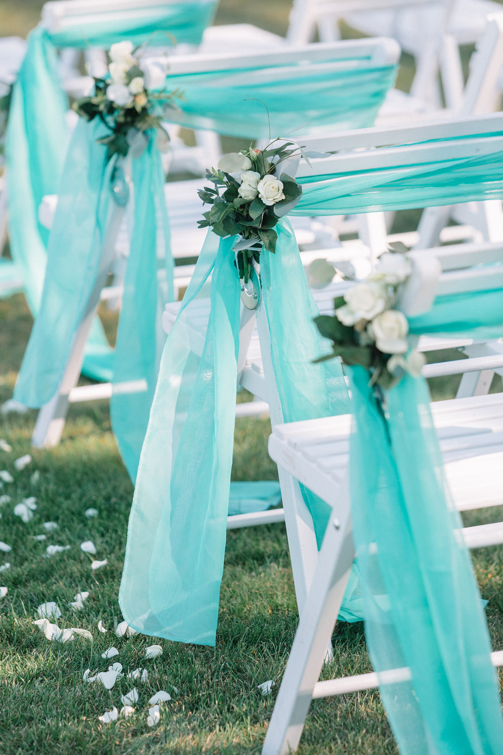 Turquoise fabric on white chairs—an ideal inspiration for your destination wedding decor ideas.