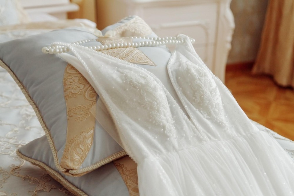 White wedding dress and pearl necklace—ideal for a destination wedding! Get expert tips on packing and transporting your wedding attire with ease.