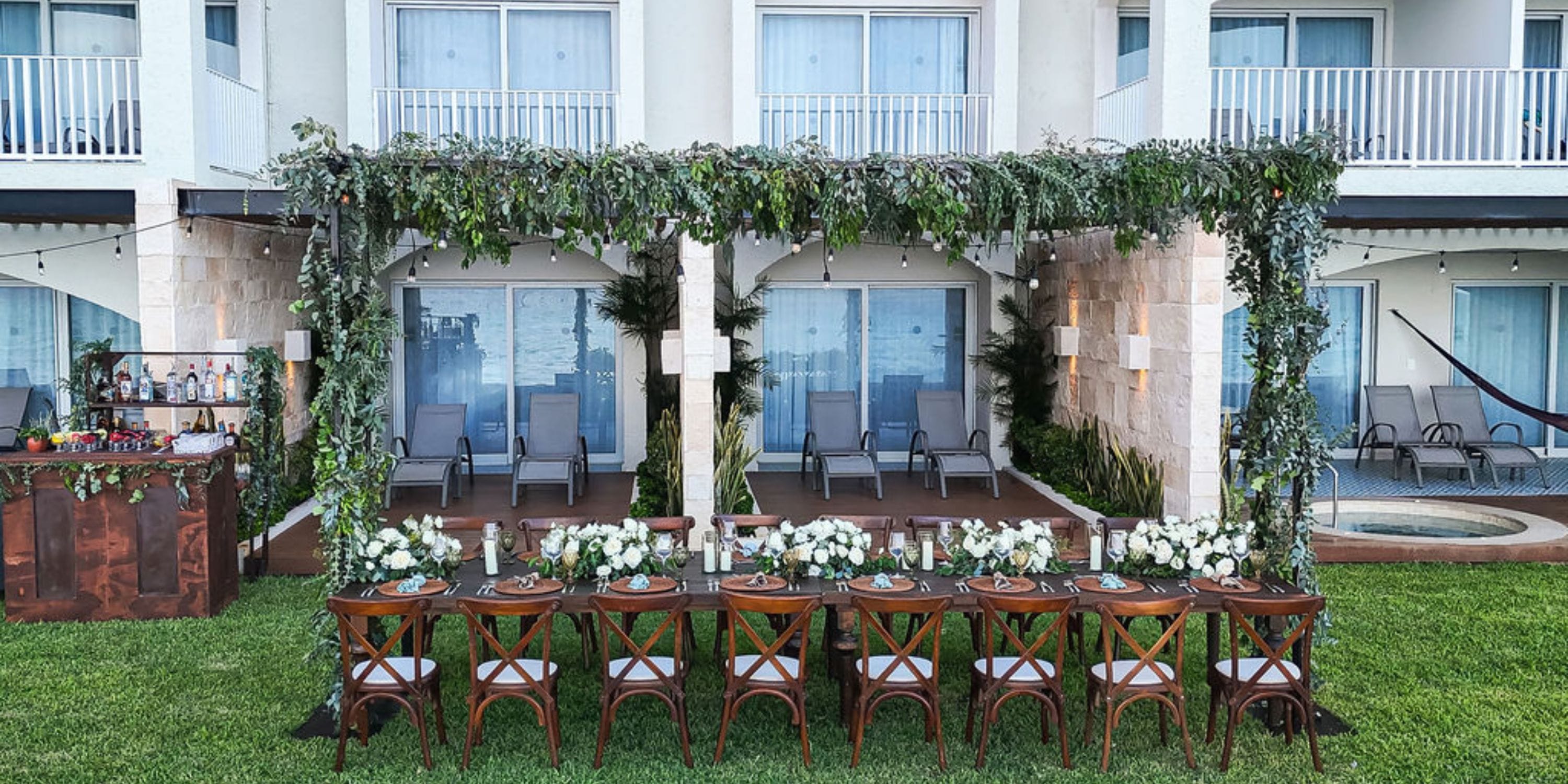 Hilton Cancun Mar Caribe outdoor dining table with wedding floral d&eacute;cor by patio and lounge chairs.