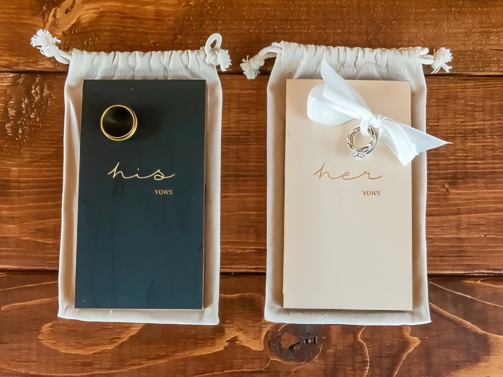 Two wedding vow books for a traditional ceremony, labeled "his" and "her," with wedding rings resting on top—perfect for capturing heartfelt promises at your destination wedding.