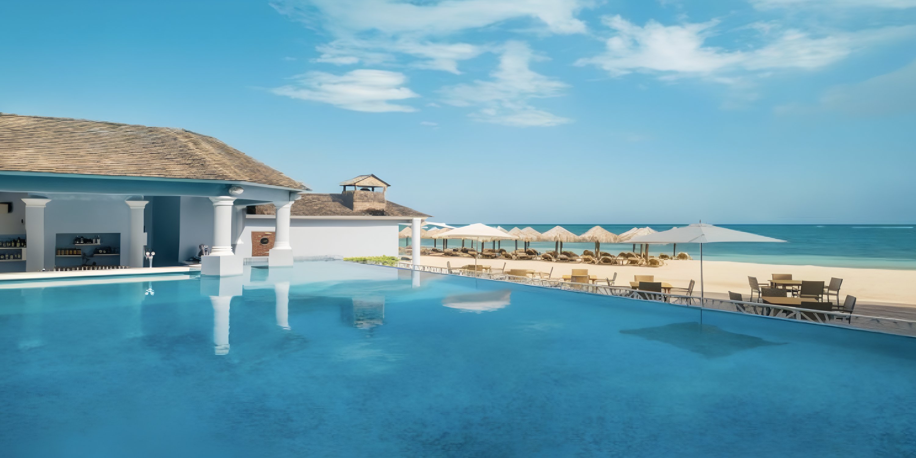 Infinity pool at JOIA Rose Hall by Iberostar, perfect for a destination wedding with lounge chairs and bar.