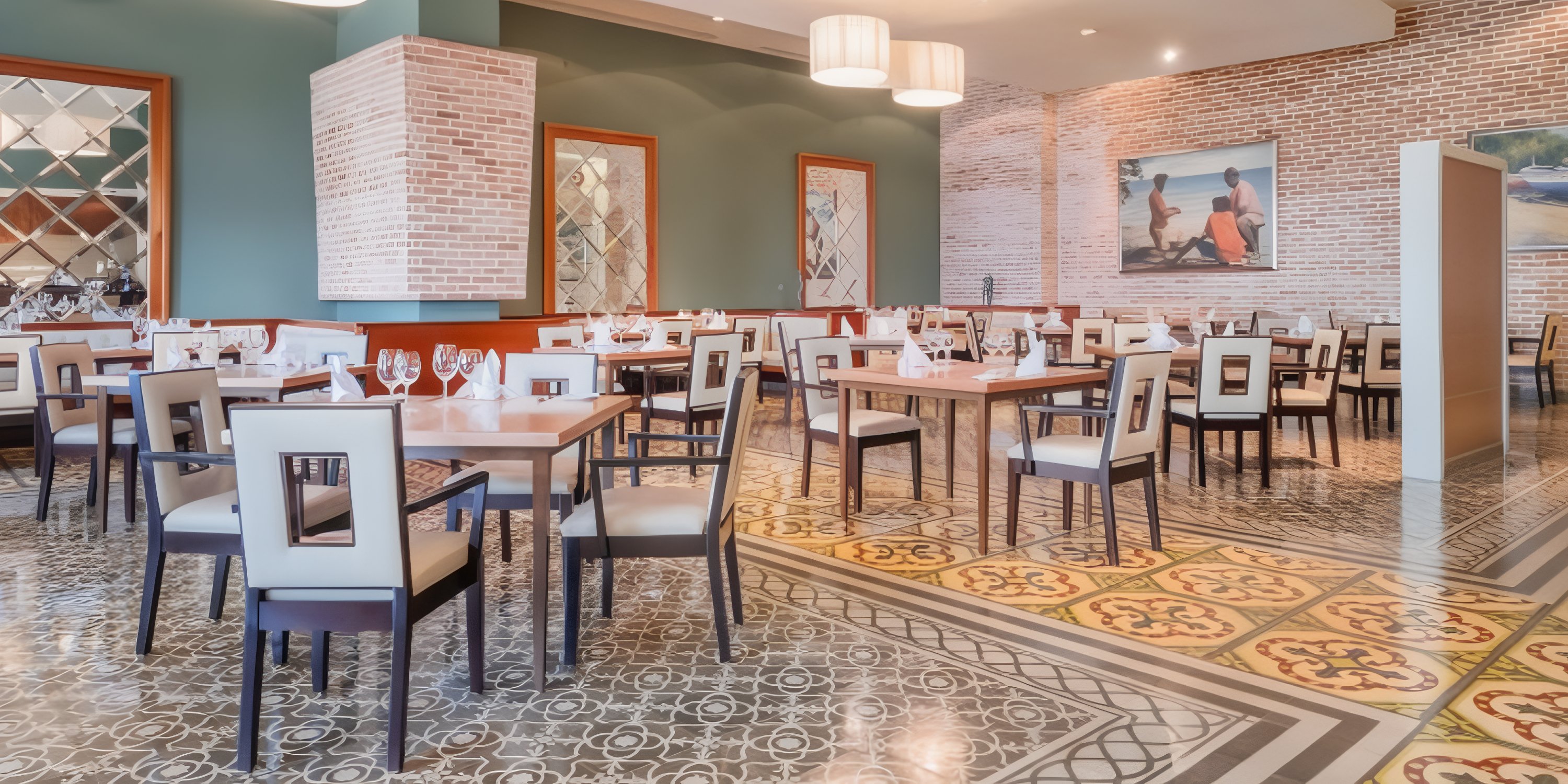 JOIA Rose Hall by Iberostar set for a destination wedding, with empty tables, chairs, and wall art.