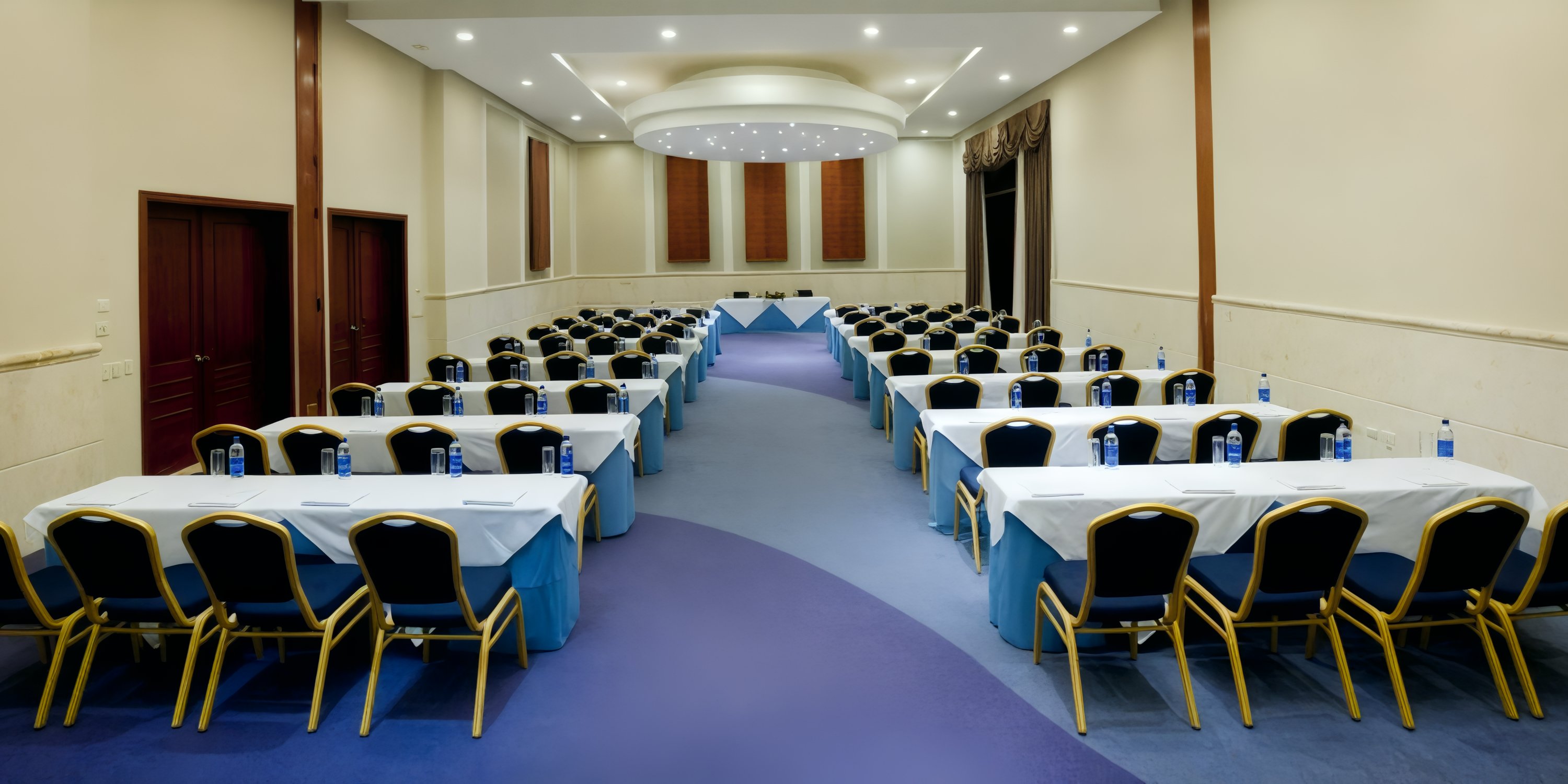 The JOIA Bavaro by Iberostar conference room is elegantly arranged with rows of tables and chairs, creating a perfect setting for a destination wedding event.
