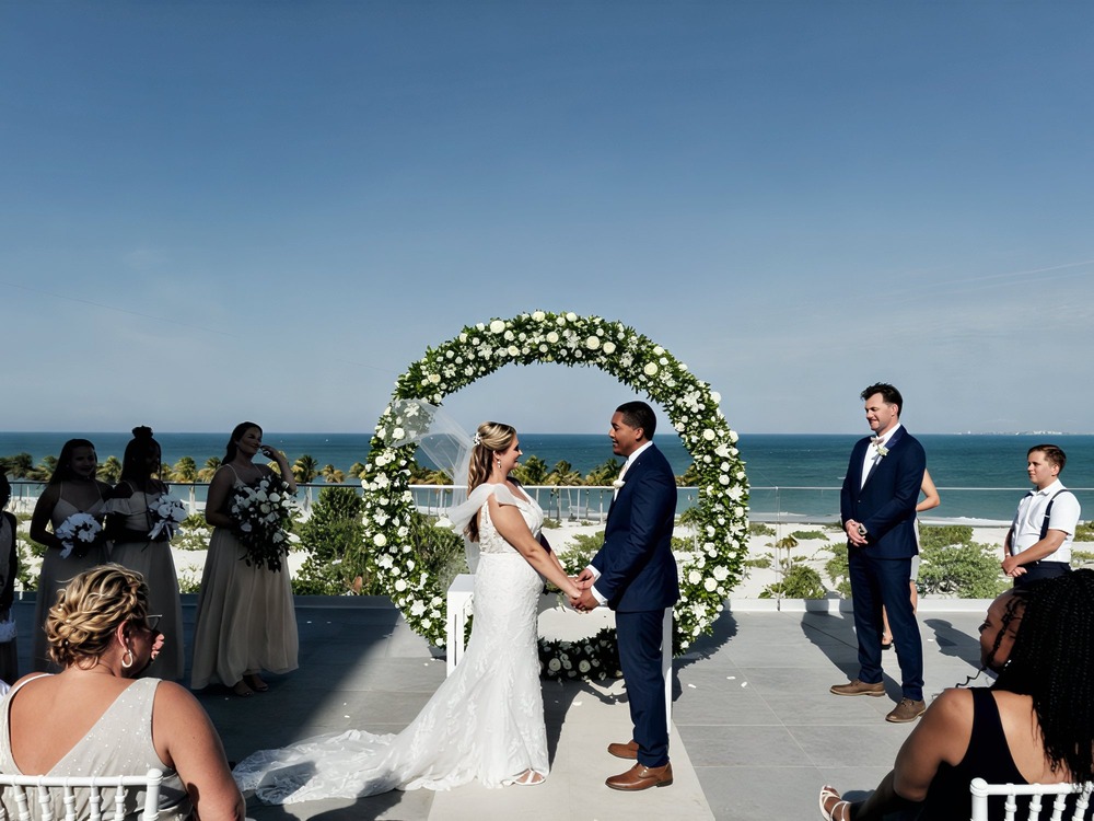 A must-have destination wedding photo: the bride and groom standing at an outdoor altar overlooking the ocean.