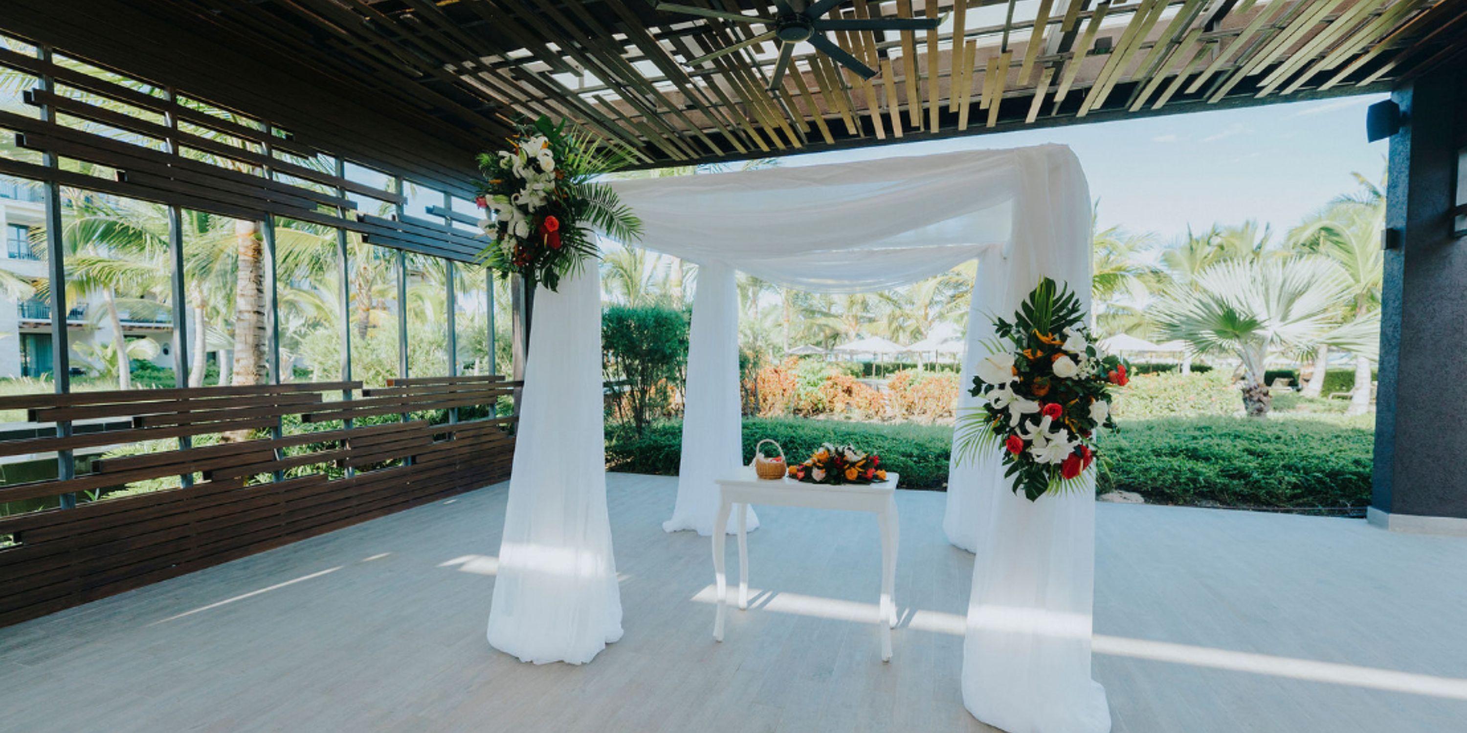 Destination wedding altar at Lopesan Costa Bavaro, adorned with white drapes and floral decorations.