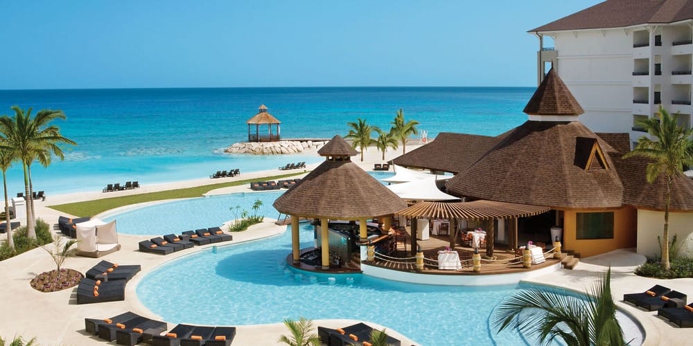Resort pool with swim-up bar and ocean view&mdash;discover destination wedding venues in Jamaica under $3K.
