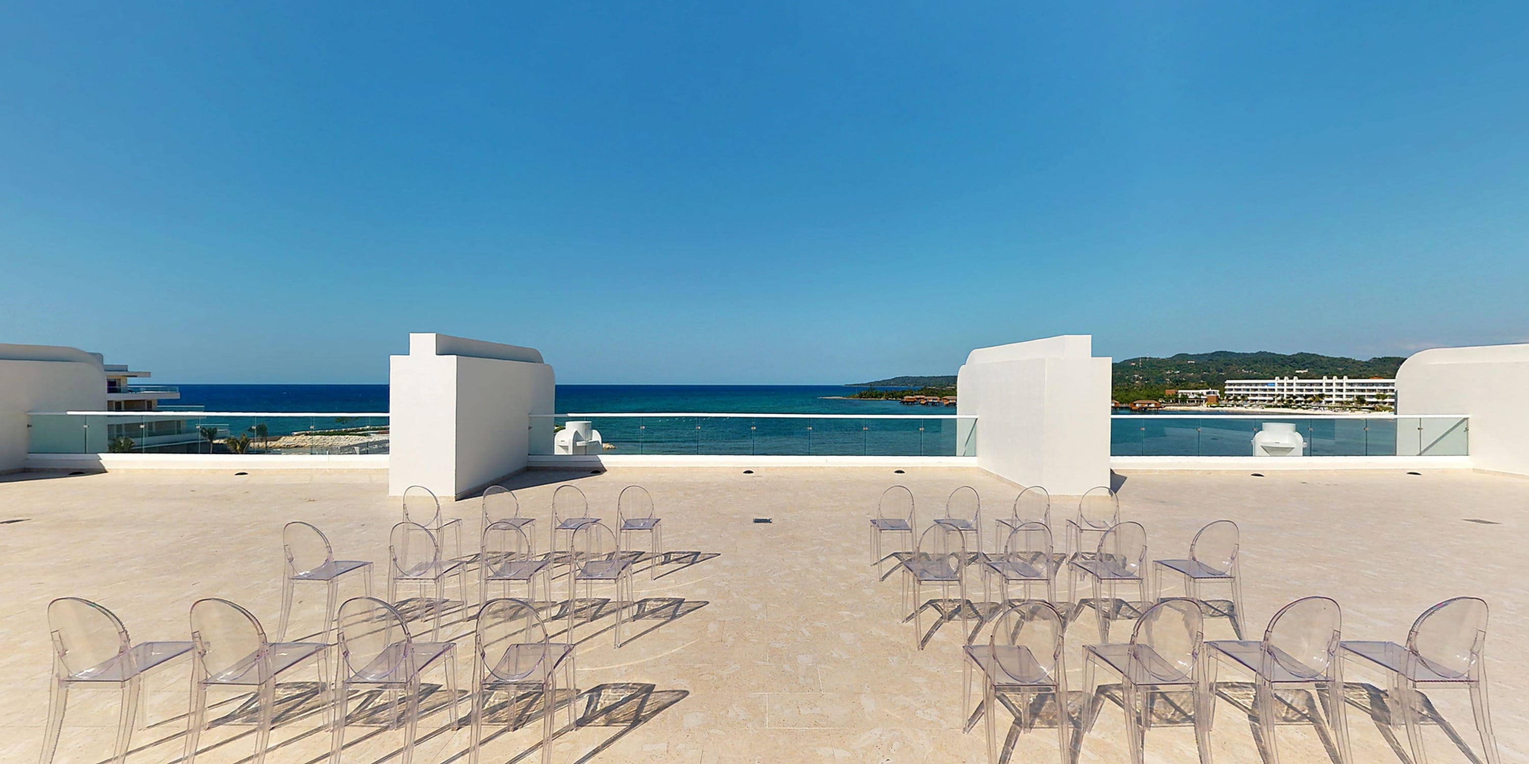 Empty chairs set up for a destination wedding on a Princess Grand Jamaica oceanfront terrace.
