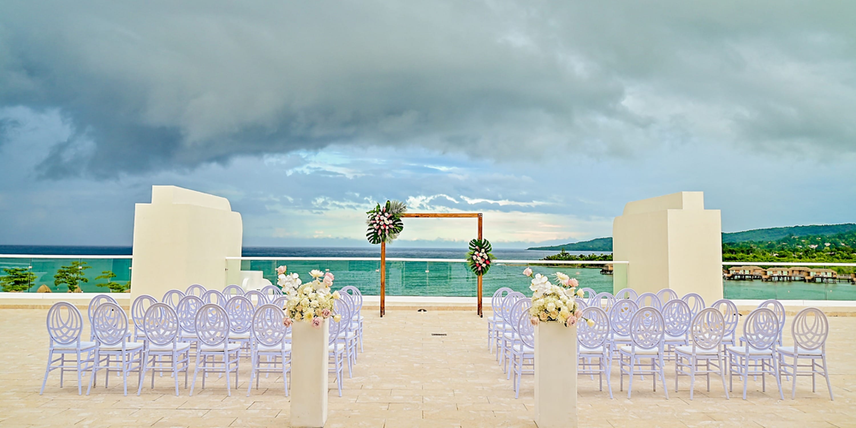 Rows of white chairs face a wedding altar overlooking the ocean at Princess Grand Jamaica.