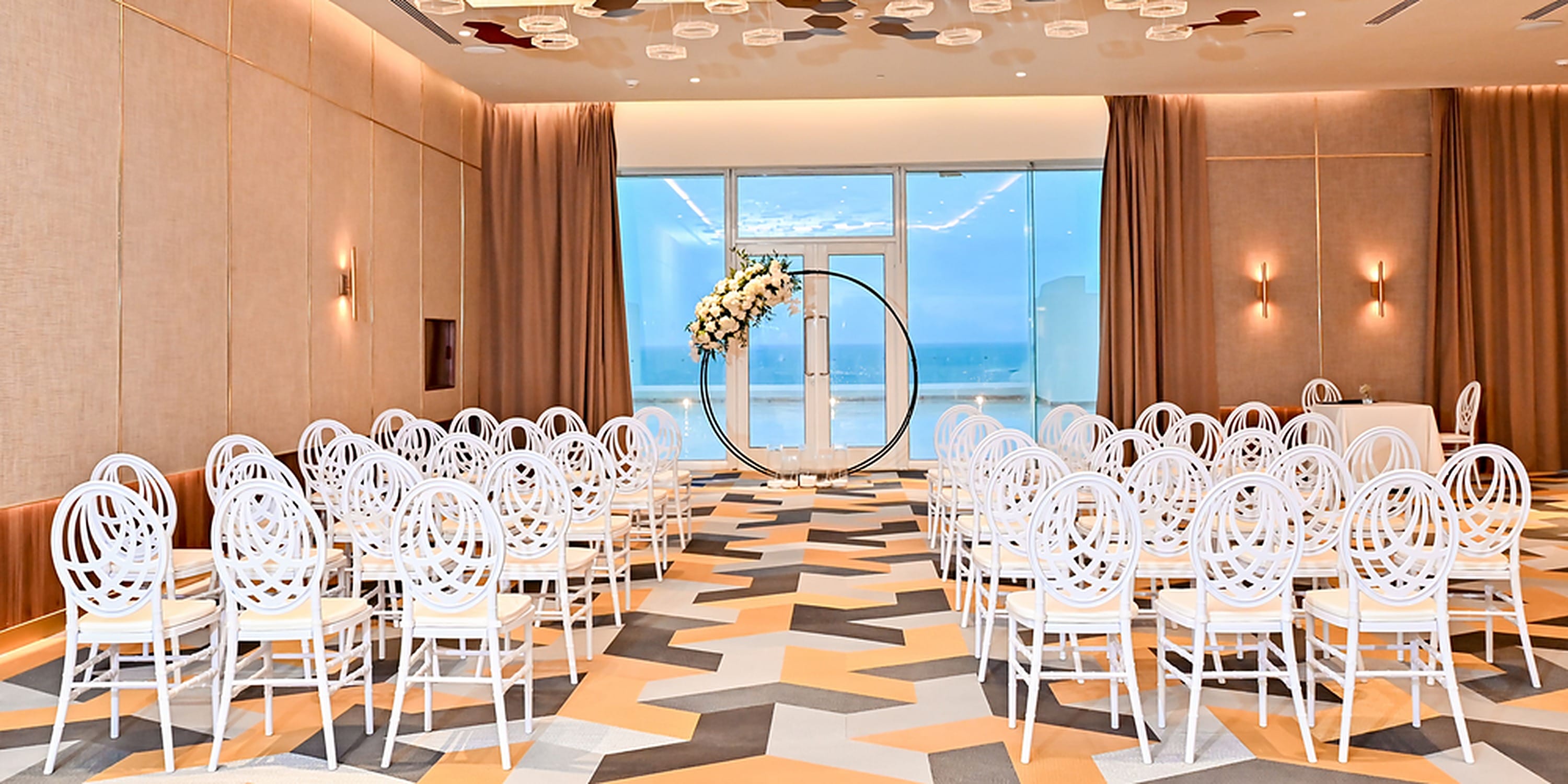 Rows of white chairs face a floral arch at a Princess Grand Jamaica destination wedding.