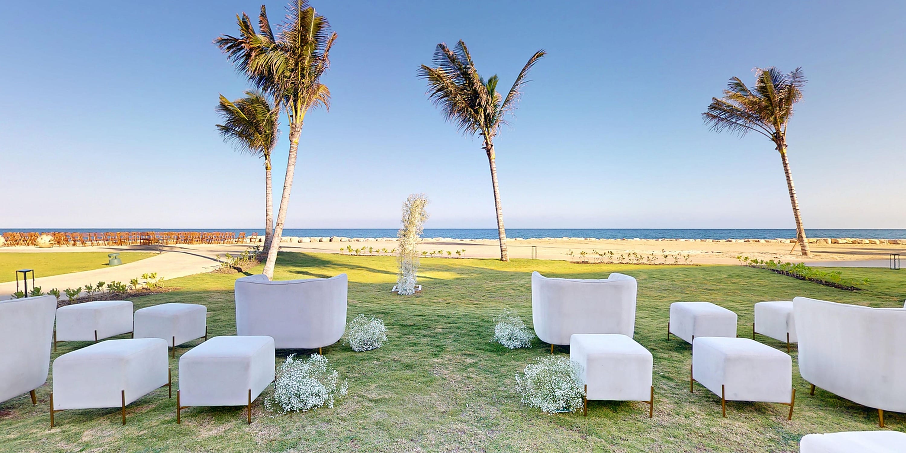 White lounge chairs and ottomans arranged for a destination wedding at Princess Grand Jamaica.