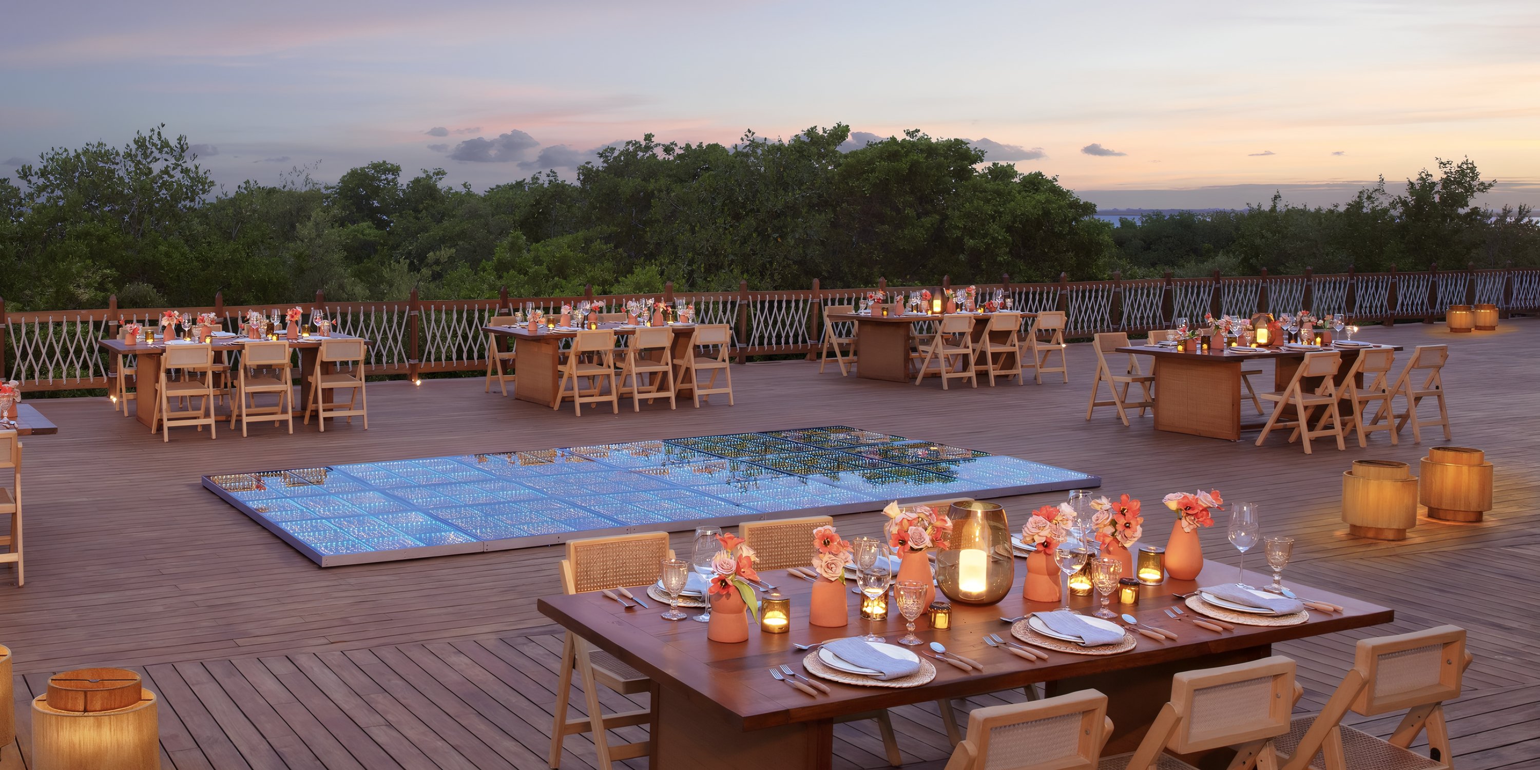 Hyatt Vivid Grand Island: Outdoor wooden patio set for dining, perfect for a destination wedding at sunset.