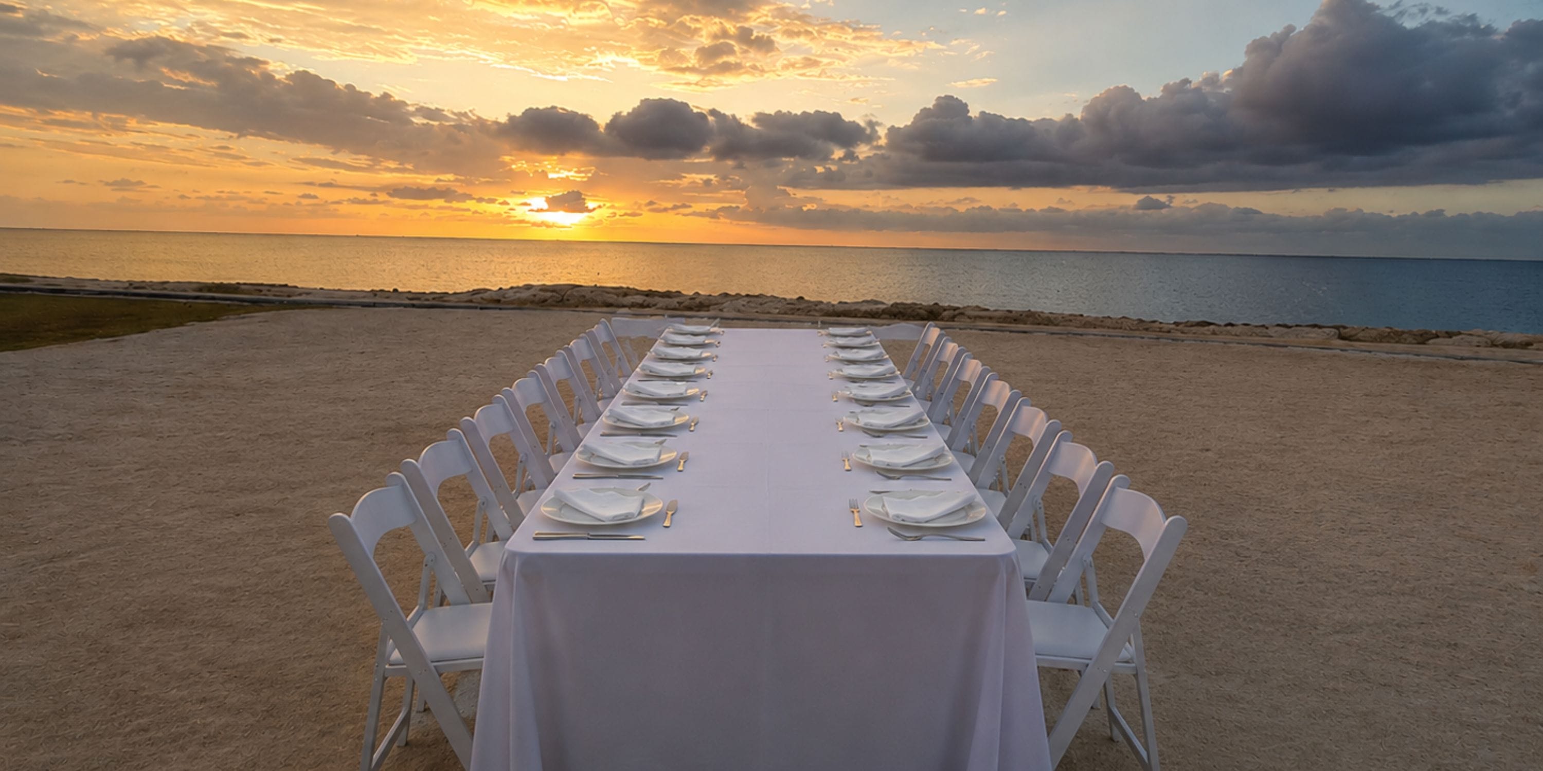 Princess Grand Jamaica: elegant white wedding table set for a destination beach sunset, ocean view.