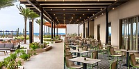 Secrets Baby Beach Aruba outdoor patio with tables and chairs, perfect for a destination wedding by the ocean.