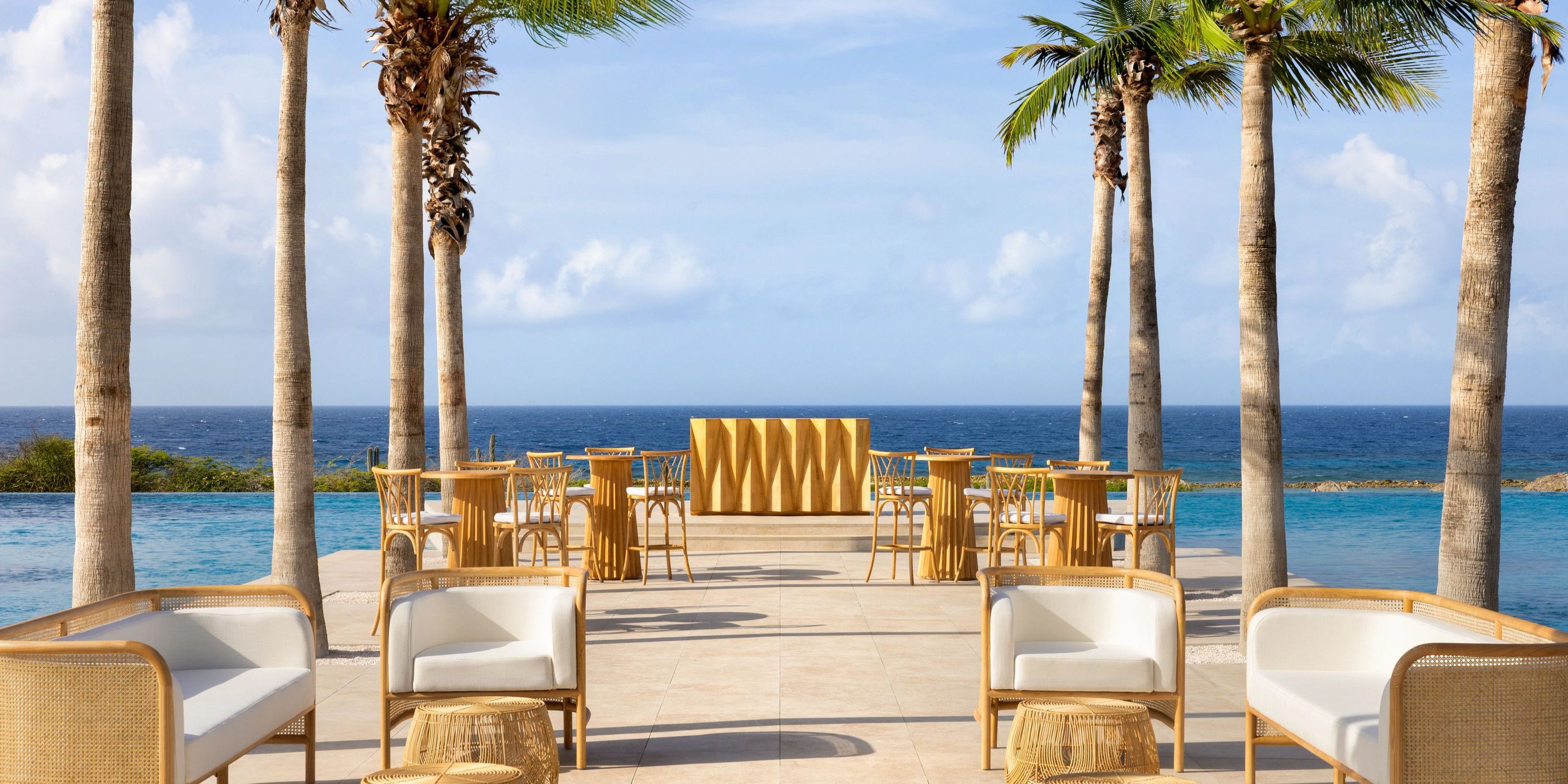 Secrets Baby Beach Aruba: Ideal for a destination wedding, with wicker lounges, pool, ocean views, palms.