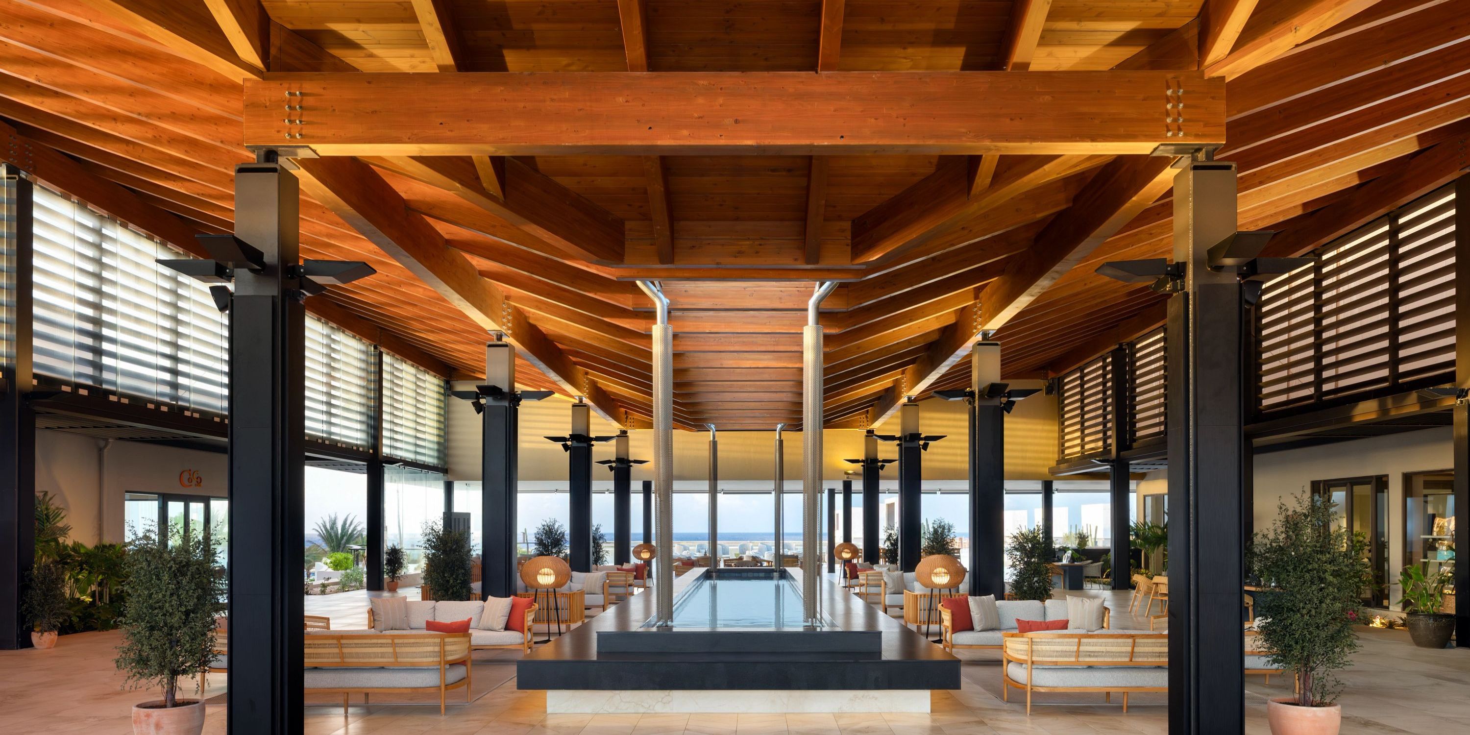 Elegant lobby at Secrets Baby Beach Aruba, ideal for a destination wedding, with beams and water feature.