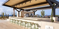 Secrets Baby Beach Aruba: ideal for a destination wedding, outdoor bar with green stools and cacti backdrop.