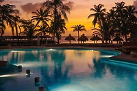 Palm trees frame the pool at Secrets St Lucia, a dreamy destination wedding spot with huts and ocean views.