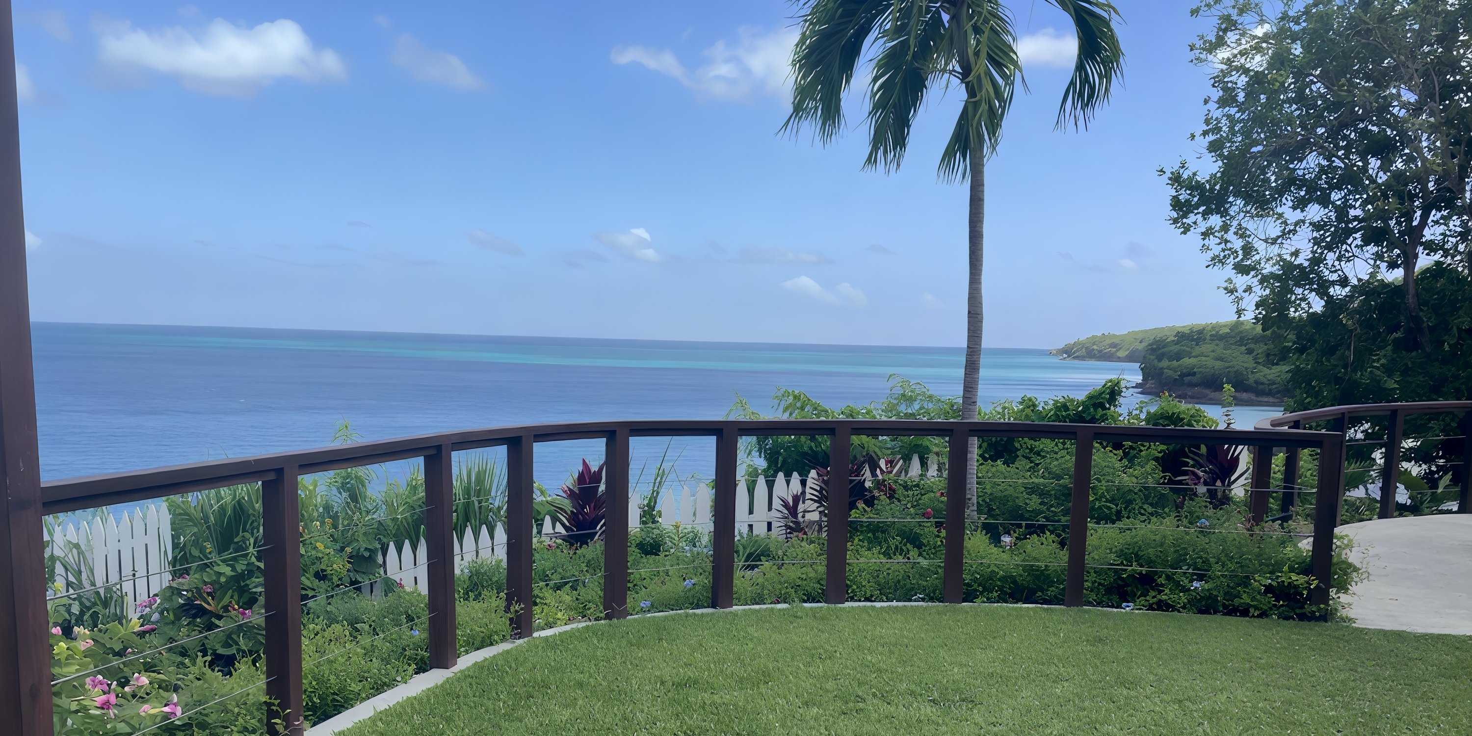 Secrets St Lucia: stunning destination wedding spot with ocean view, green lawn, palm trees & clear sky.