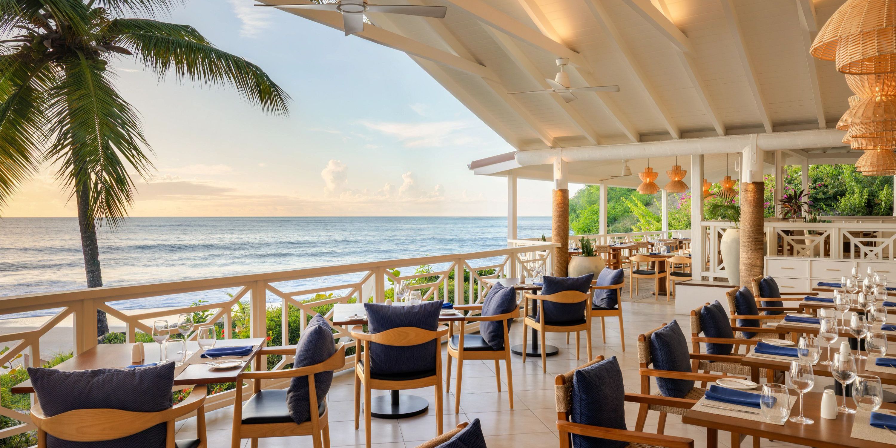 Secrets St Lucia: Beachfront dining with wooden tables, blue cushions&mdash;perfect for a destination wedding.