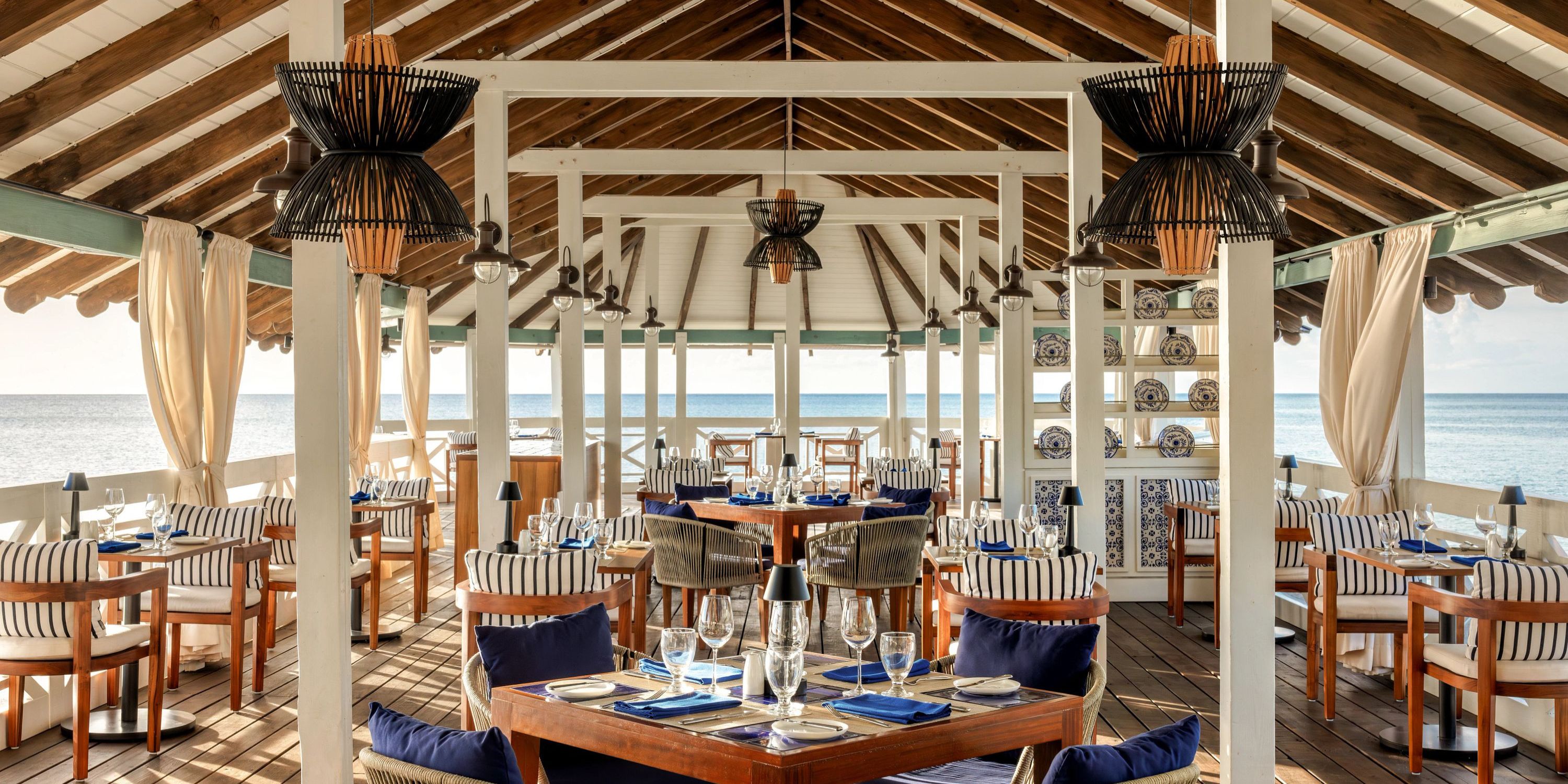 Secrets St Lucia: open-air seaside dining with wooden ceiling&mdash;perfect for a romantic destination wedding.
